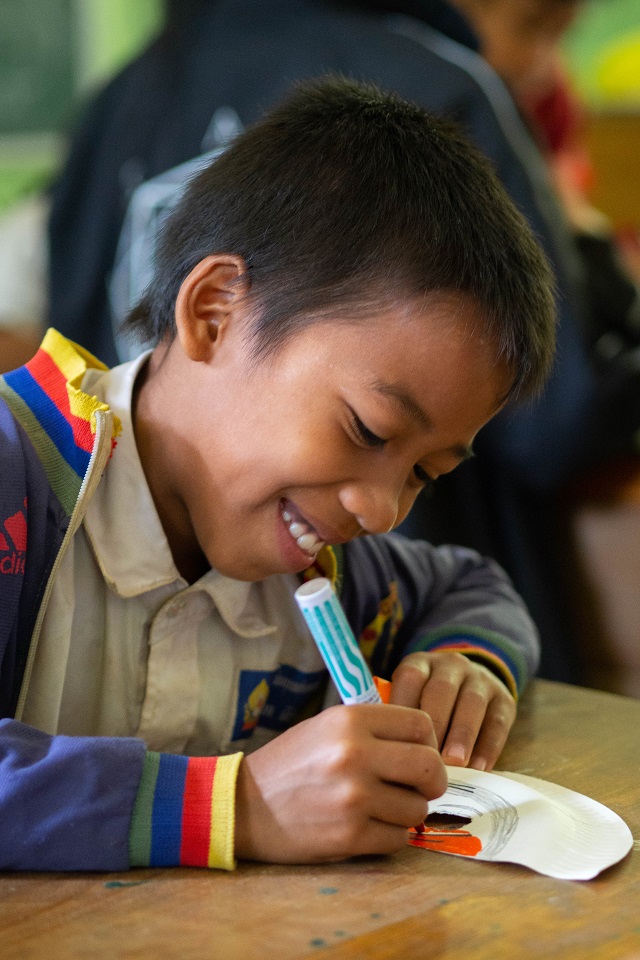 All smiles from Lang and the children as they use their creativity to create their own paper masks!