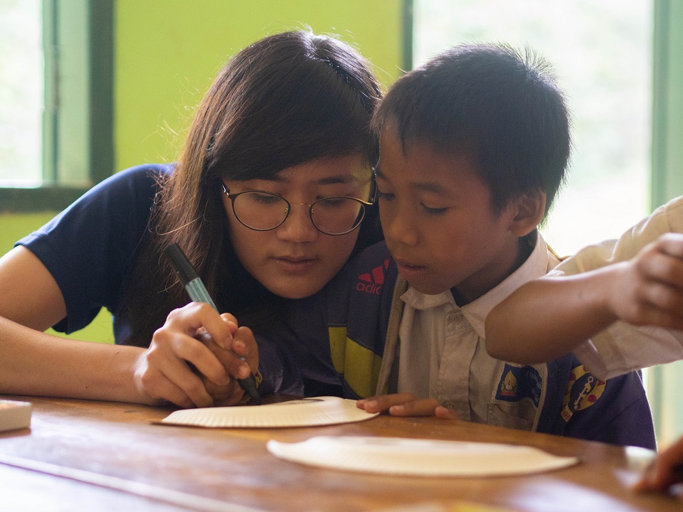 Our volunteer, Zhi Xin, helping the children to design their paper masks.