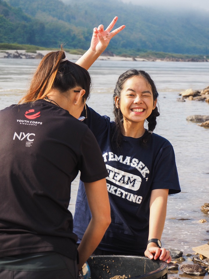 Stephanie posing for the camera while in the midst of washing rocks for the water filtration tank!